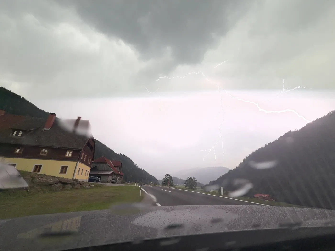 Before: a strike above a mountain road, faint and crossed by a bright horizontal band.